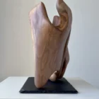 rebirth-wood-sculpture-side-view-ewebohome Side view of a walnut sculpture on a raw stone base, highlighting contrast between wood and slate.