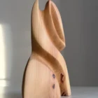 hand carved sculpture in pear wood with visible knots and organic shape