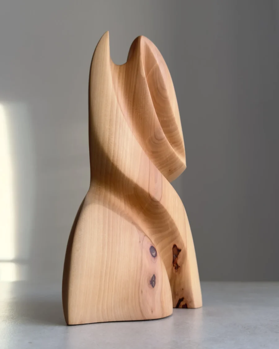hand carved sculpture in pear wood with visible knots and organic shape