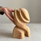 abstract wooden sculpture Seed Form shown with hand for scale