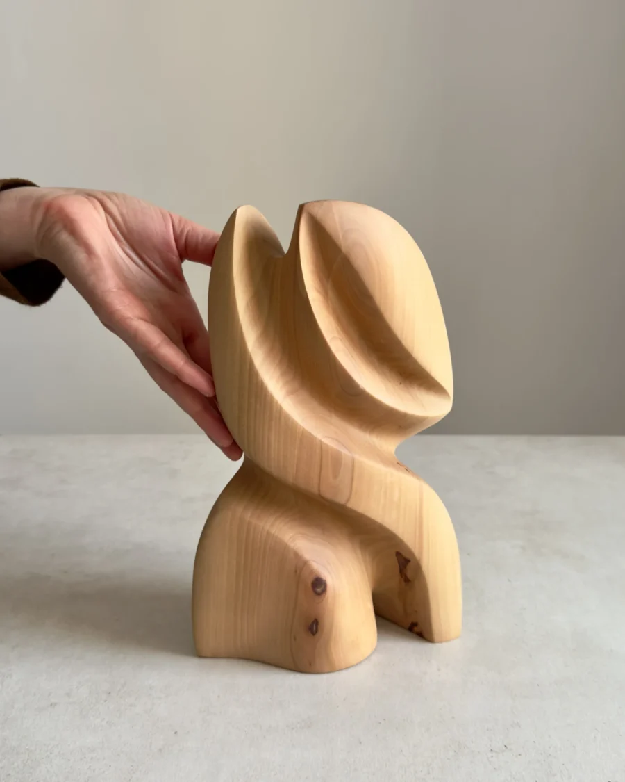 abstract wooden sculpture Seed Form shown with hand for scale