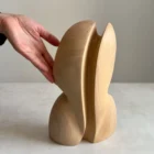 abstract wooden sculpture Seed Form shown back view with hand for scale