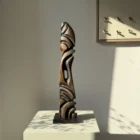 Sentinel hand carved black beech wood sculpture on a polished black granite base, front view.