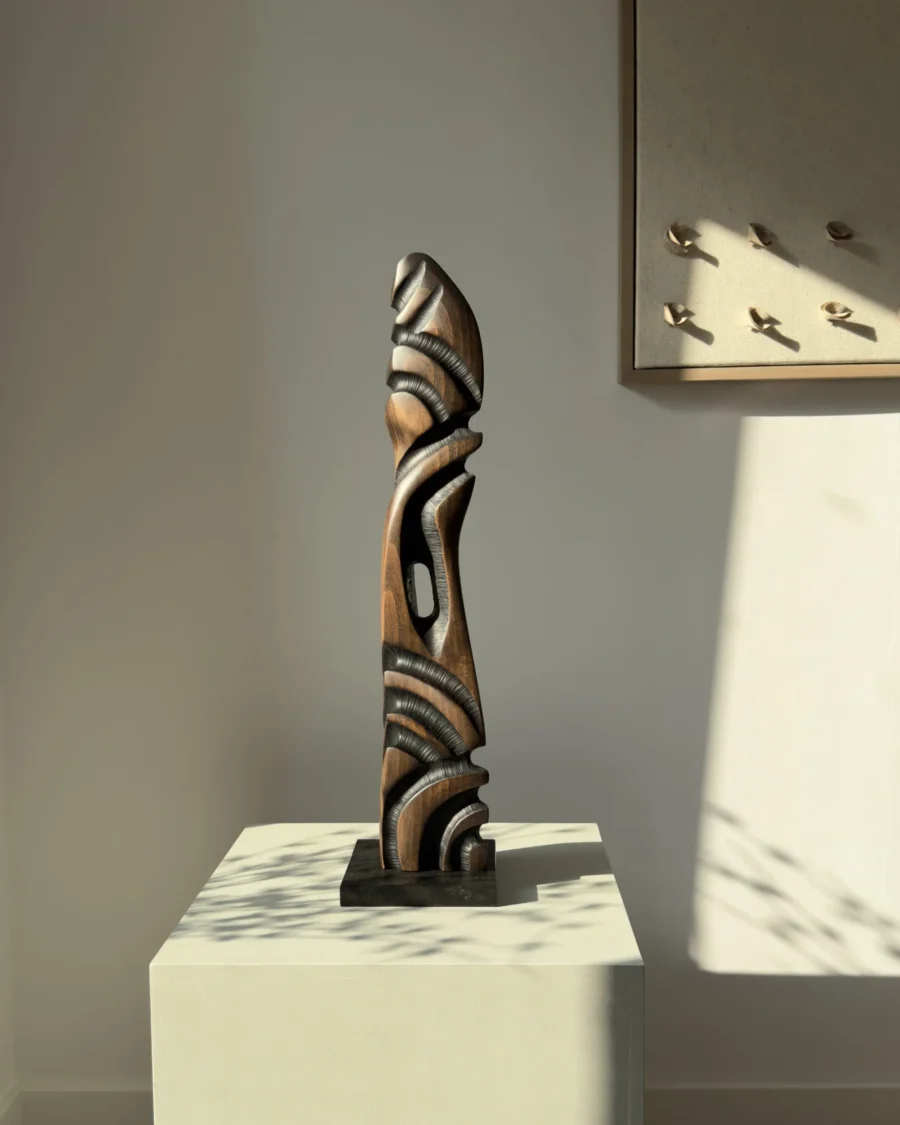 Sentinel hand carved black beech wood sculpture on a polished black granite base, front view.
