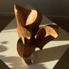 threefold-balance-top-view-walnut-sculpture Top view of hand carved walnut sculpture showing flowing openings and layered organic forms