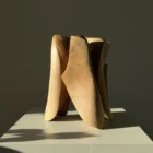 threefold-balance-walnut-wood-sculpture-front-light Contemporary walnut wood sculpture photographed from profile angle in dramatic sunlight