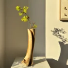 walnut-wood-vase-with-flowers-natural-light walnut wood vase with fresh branches in natural light showing sculptural form