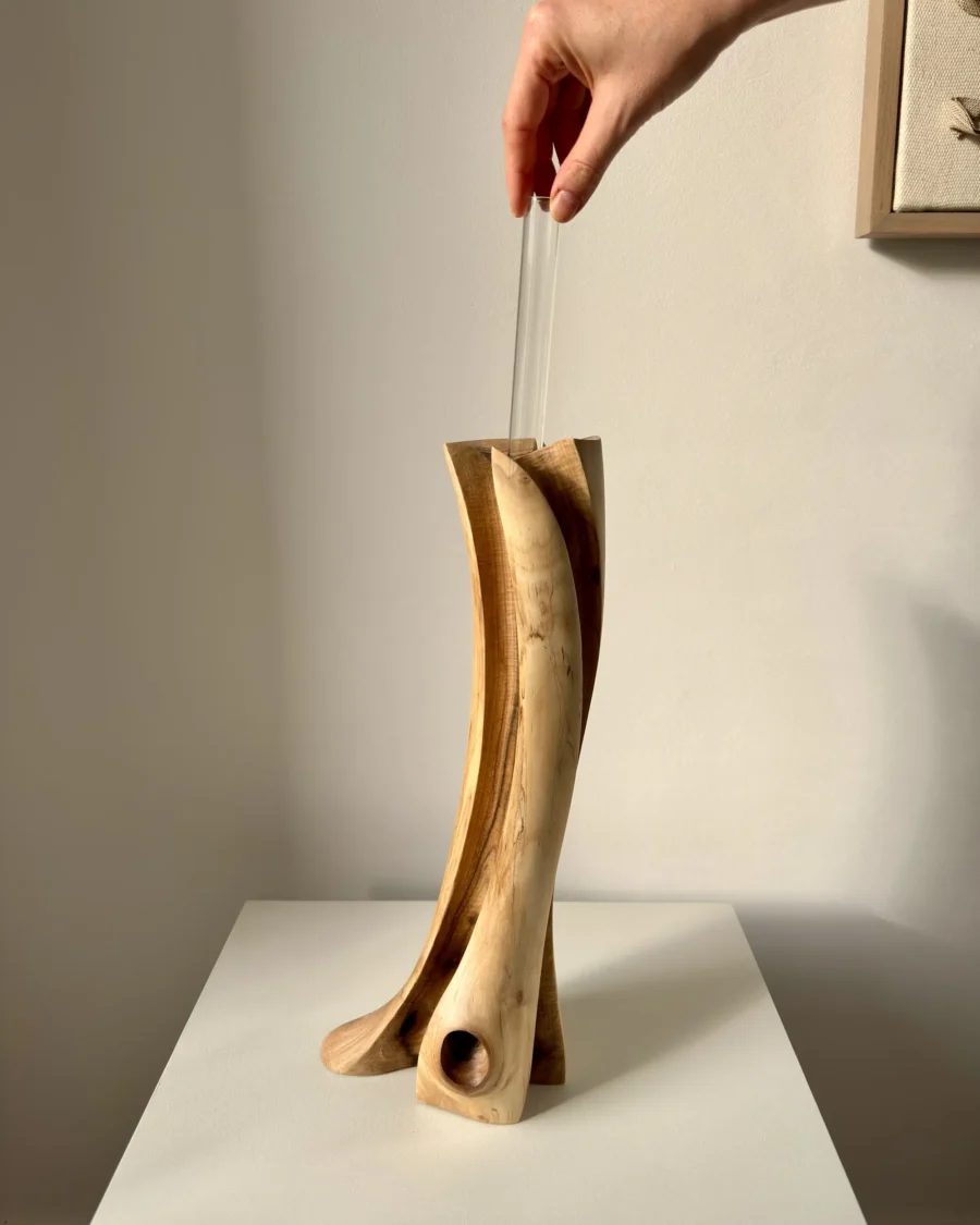 wood-vase-glass-tube-insert hand placing glass tube into hand carved walnut wood vase for fresh flowers