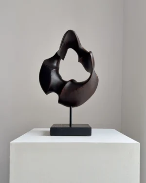 flame-memory-walnut-wood-sculpture-front-view-ewebohome Hand-carved walnut wood sculpture “Flame Memory” with fire-charred black surface on steel stand, front view in natural light