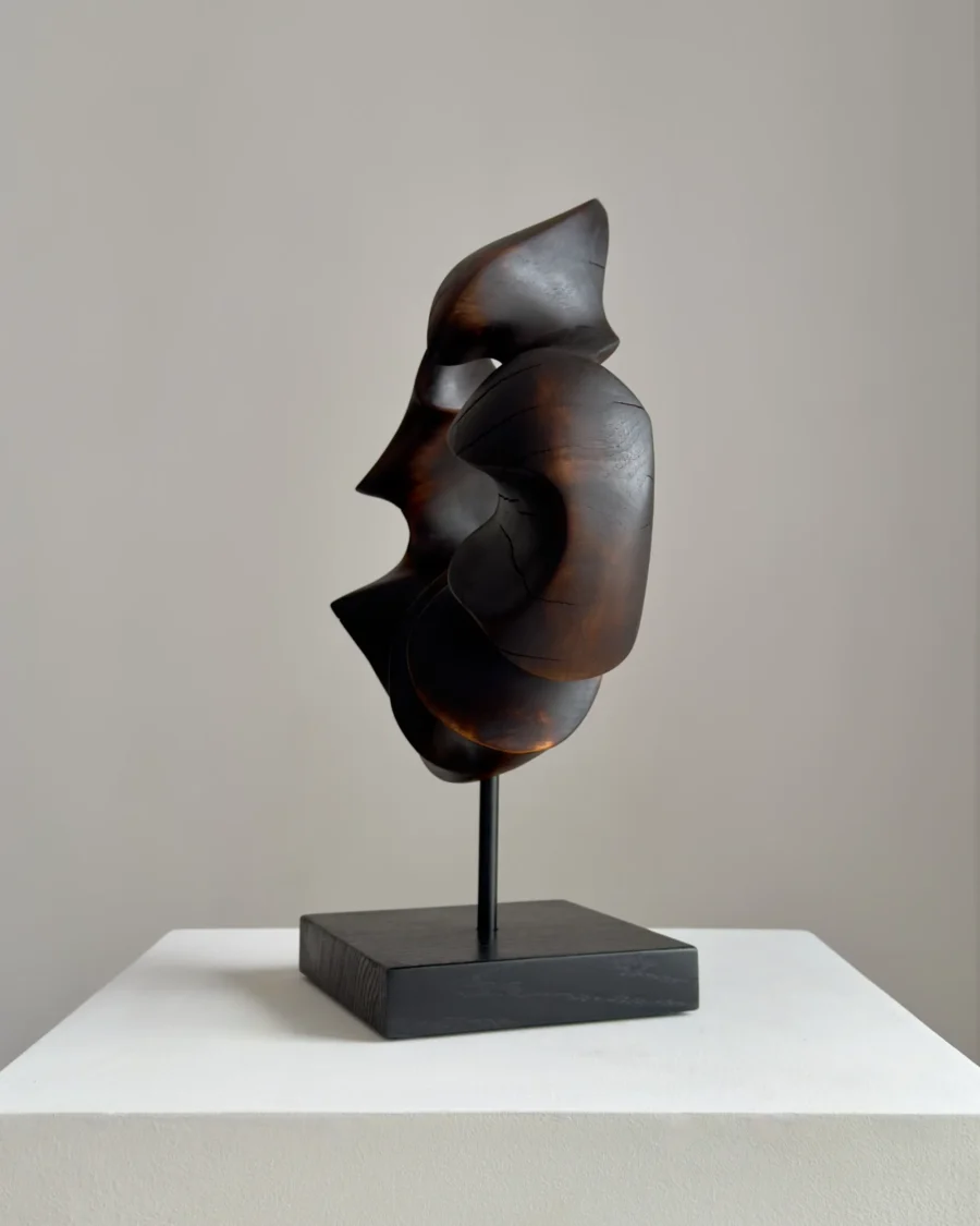 flame-memory-side-view-abstract-walnut-sculpture Side view of dark abstract walnut sculpture with flowing organic lines and sculptural opening