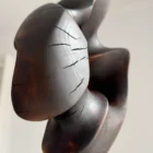 flame-memory-charred-wood-sculpture-detail-cracks Close-up detail of fire-charred walnut sculpture surface with natural heat cracks and dark matte finish