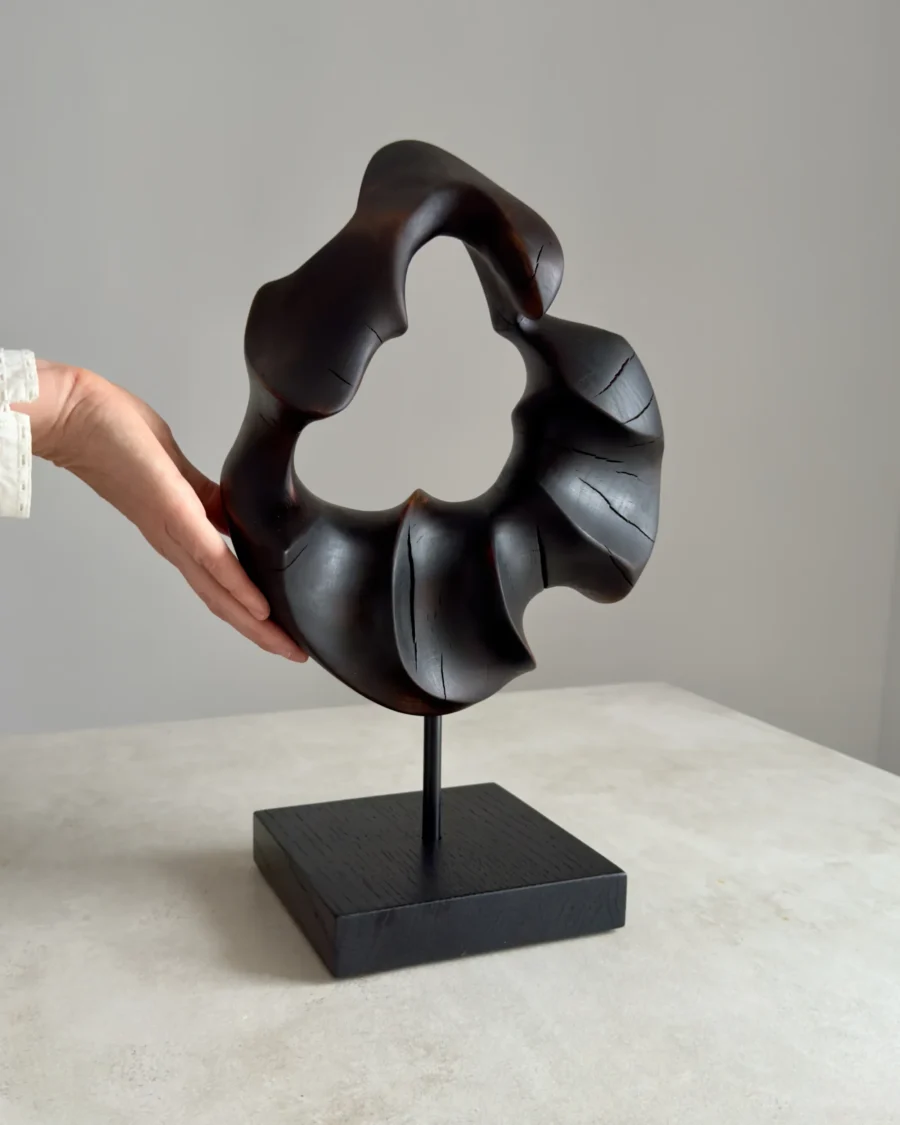 flame-memory-walnut-sculpture-scale-photo Hand beside abstract walnut sculpture “Flame Memory” showing scale and smooth fire-charred surface