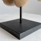 wooden sculpture on black granite base