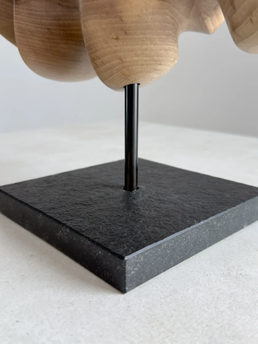wooden sculpture on black granite base