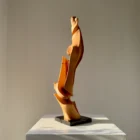 Vertical abstract wood sculpture in natural light minimalist setting