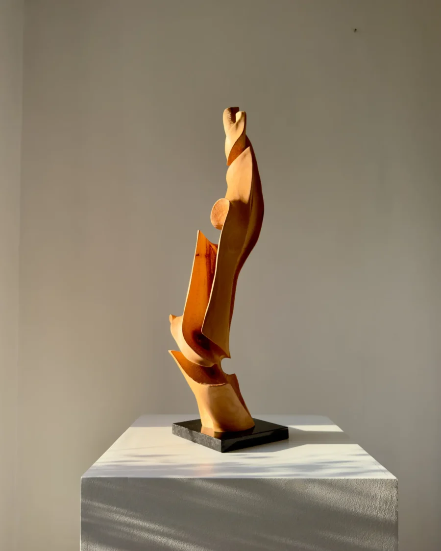 Vertical abstract wood sculpture in natural light minimalist setting