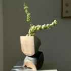 Modern organic wooden vase with single white flowers in Japandi style interior light