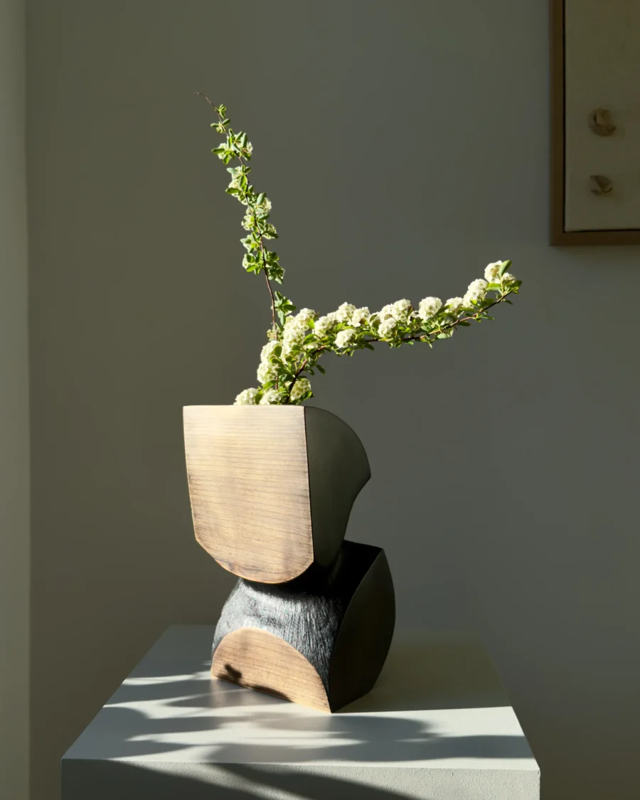 Modern organic wooden vase with single white flowers in Japandi style interior light