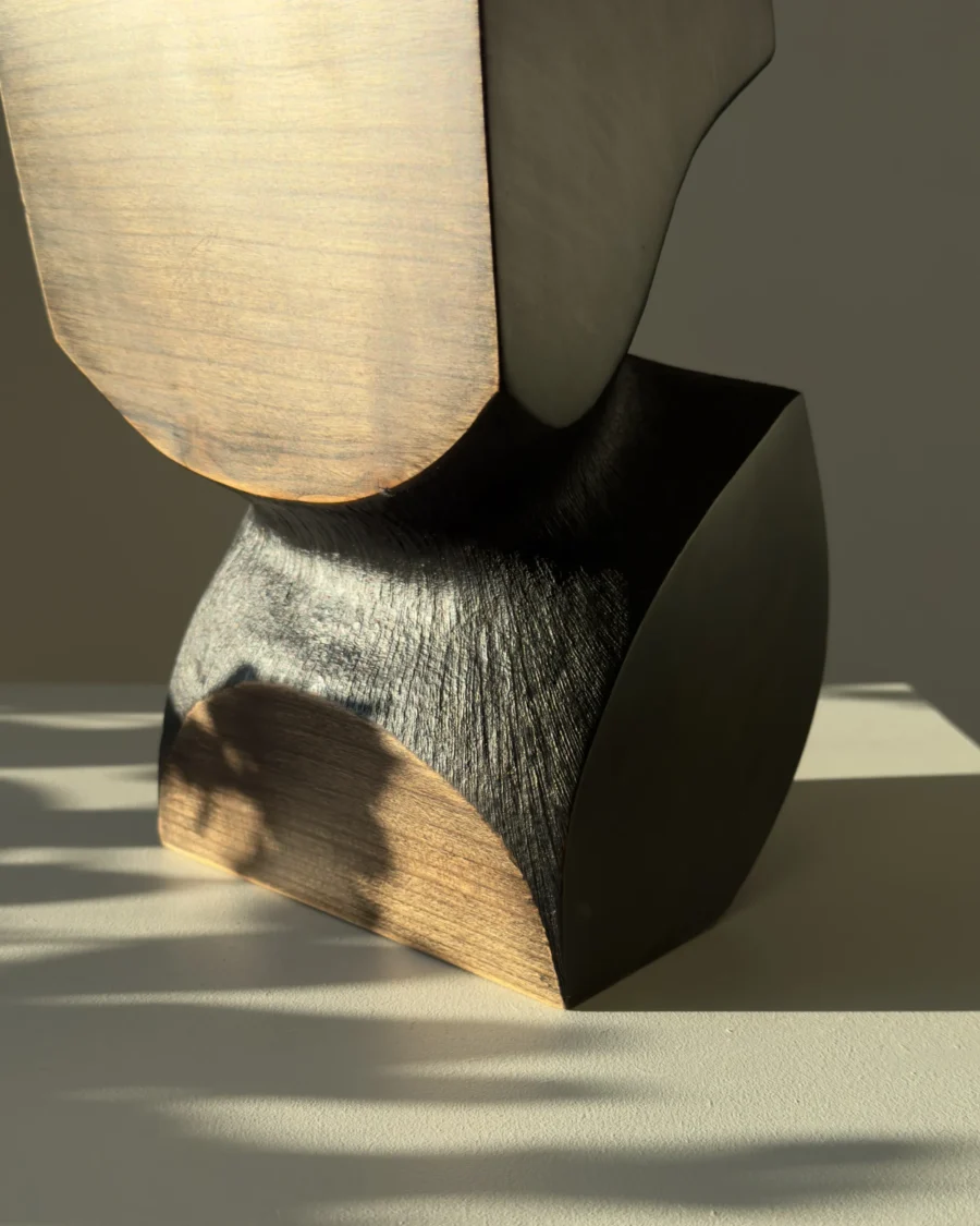 Hand carved apple wood vase showing natural grain and black textured surface