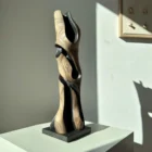 Side view of “Noctivis” abstract wooden sculpture showing sculptural shadow and flowing vertical form in natural light.