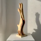 Rising Form hand carved applewood sculpture on travertine base viewed from the front