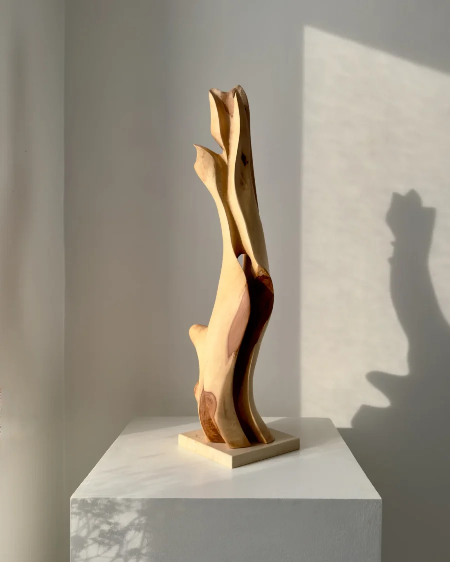 Rising Form hand carved applewood sculpture on travertine base viewed from the front