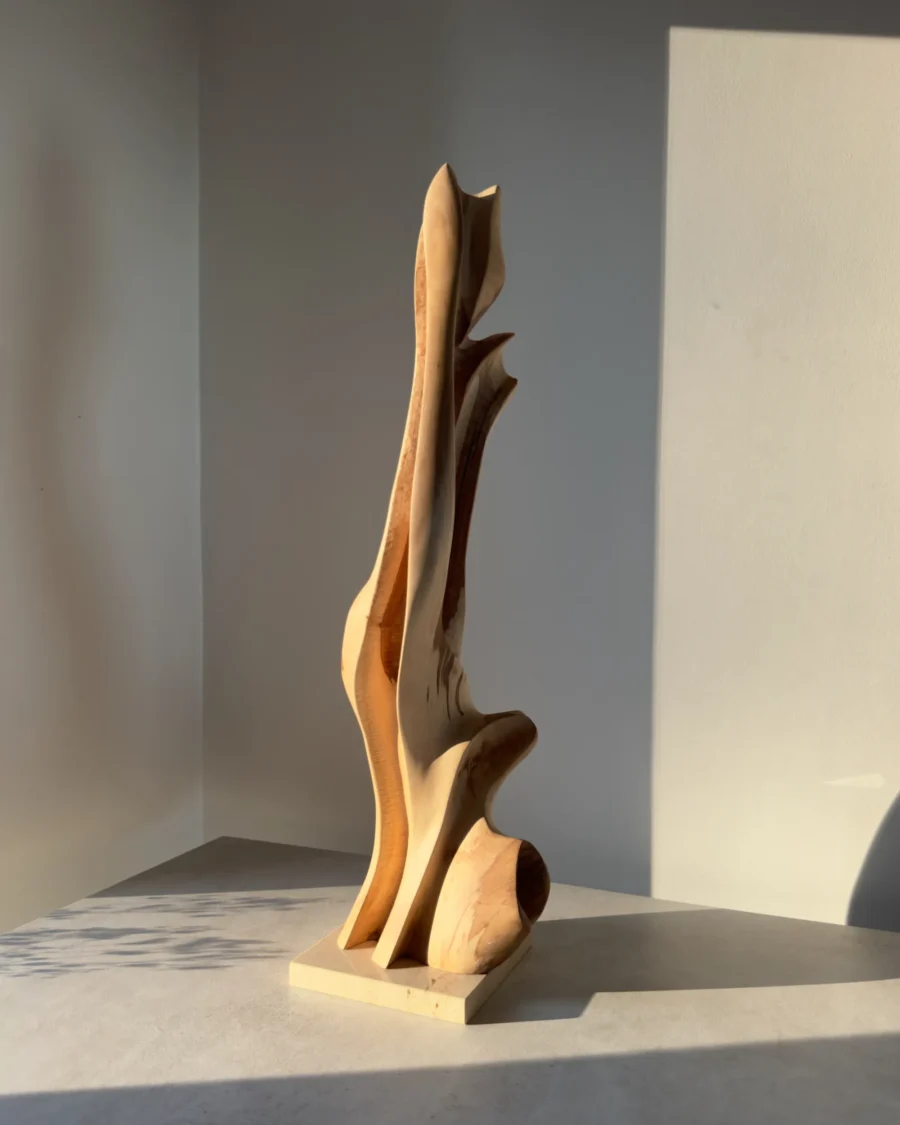 Side view of Rising Form abstract applewood sculpture with flowing organic curves