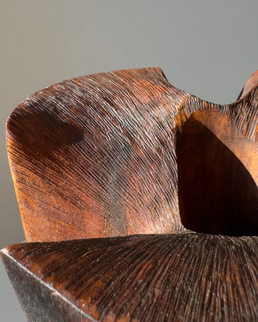 Close-up of burned and brushed walnut wood texture on sculptural vase