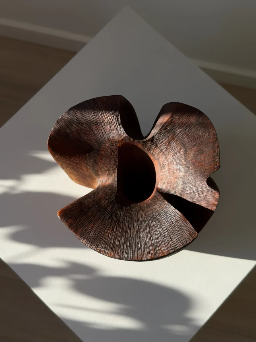 Top view of sculptural walnut wood vase with organic carved opening