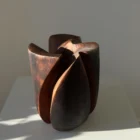 Sculptural walnut wood vase with organic asymmetrical form and brushed burned texture