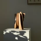 threefold-balance-minimalist-walnut-art-object Walnut wood sculpture interacting with strong natural light and shadow on a white pedestal