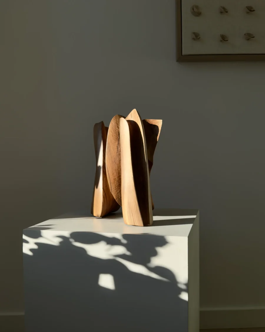 threefold-balance-minimalist-walnut-art-object Walnut wood sculpture interacting with strong natural light and shadow on a white pedestal