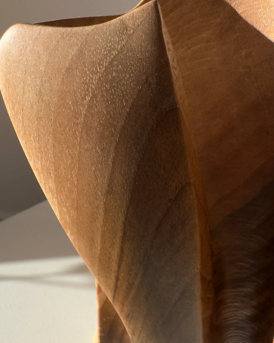 threefold-balance-organic-walnut-form-closeup-smooth-surface Close up detail of walnut wood grain and hand carved texture on abstract sculpture