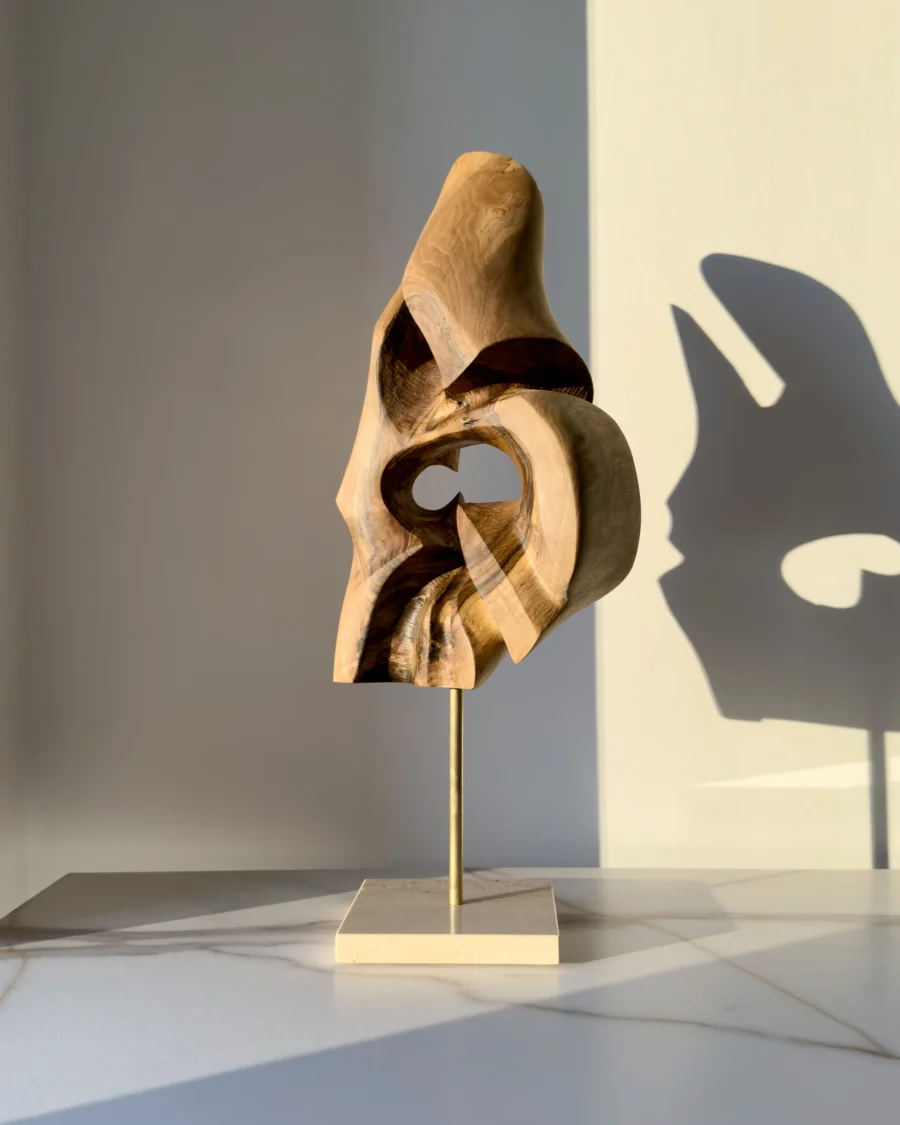 through-the-light-walnut-form-travertine-base Walnut wood abstract sculpture mounted on travertine stone base with brass rod connection