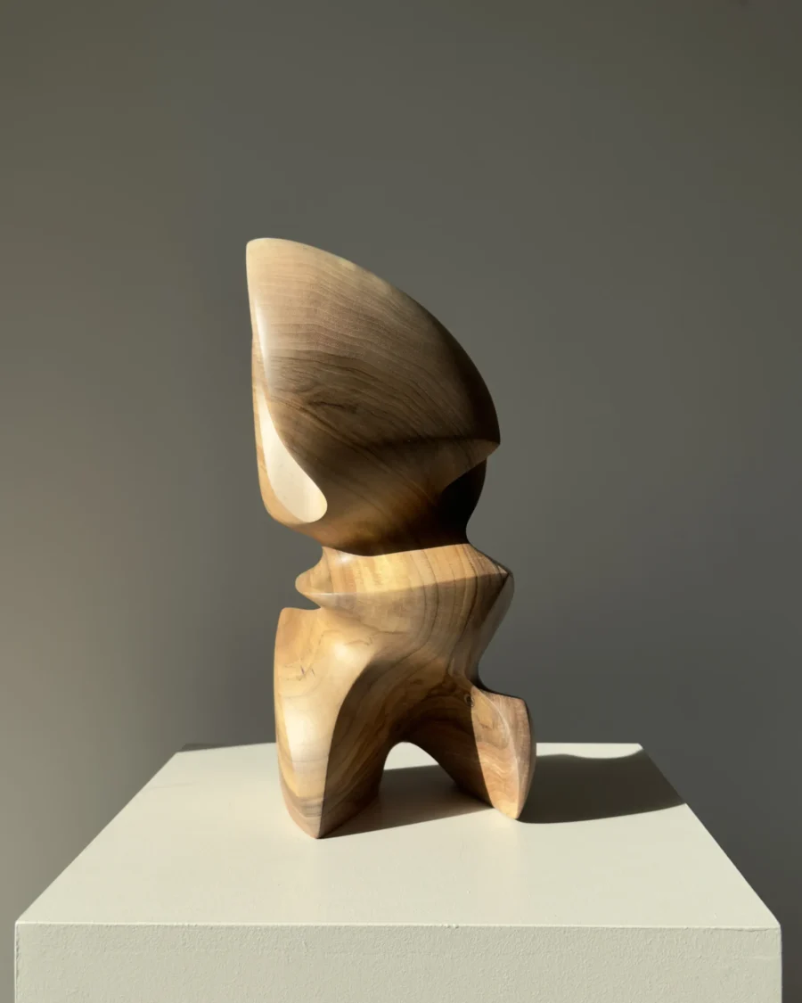 Back view of Aureon walnut wood sculpture with an open base, flowing lines and natural variations in the wood.