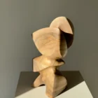 Three-quarter view of Aureon abstract wood sculpture showing light, shadow, natural walnut grain and balanced organic form.