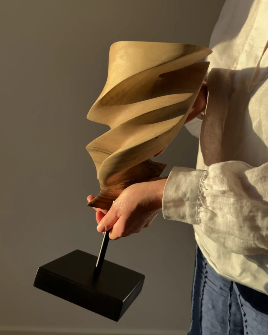 The artist holding Breath of Fire, a one-of-a-kind hand-carved walnut wood sculpture