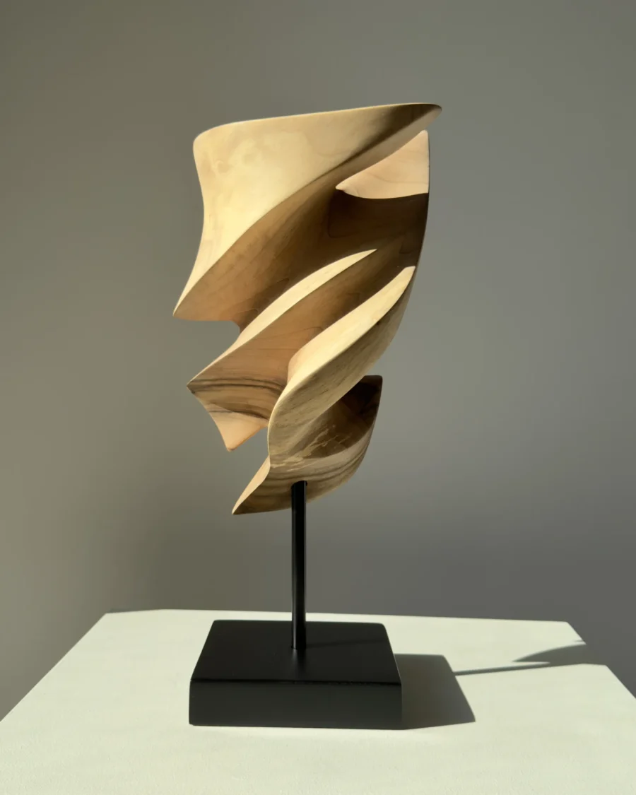 Breath of Fire walnut wood sculpture in natural sunlight within a contemporary interior setting