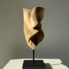 Side view of Breath of Fire hand-carved walnut sculpture with flowing organic curves