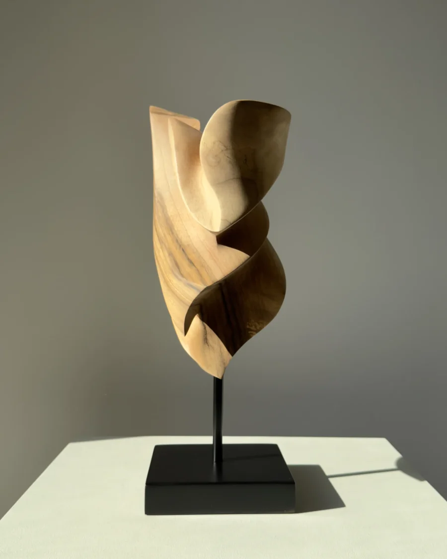Side view of Breath of Fire hand-carved walnut sculpture with flowing organic curves