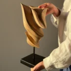 Breath of Fire walnut wood sculpture held in the artist's hands showing scale and handcrafted details