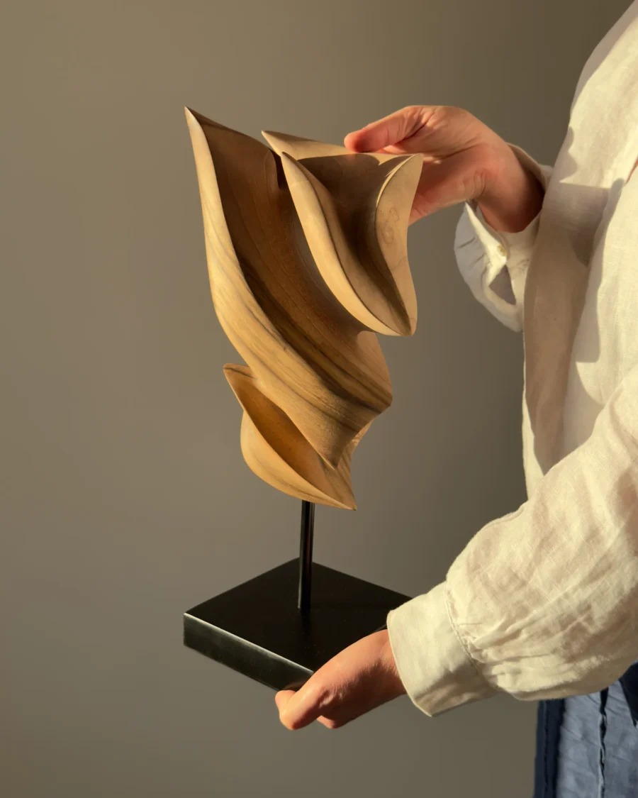 Breath of Fire walnut wood sculpture held in the artist's hands showing scale and handcrafted details