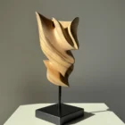Breath of Fire hand-carved walnut wood sculpture displayed in natural sunlight on a black beechwood base