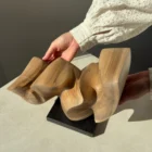 confluence-abstract-walnut-sculpture-top-view-in-hands-3 Top view of Confluence hand-carved walnut wood sculpture revealing flowing organic forms and continuous movement.