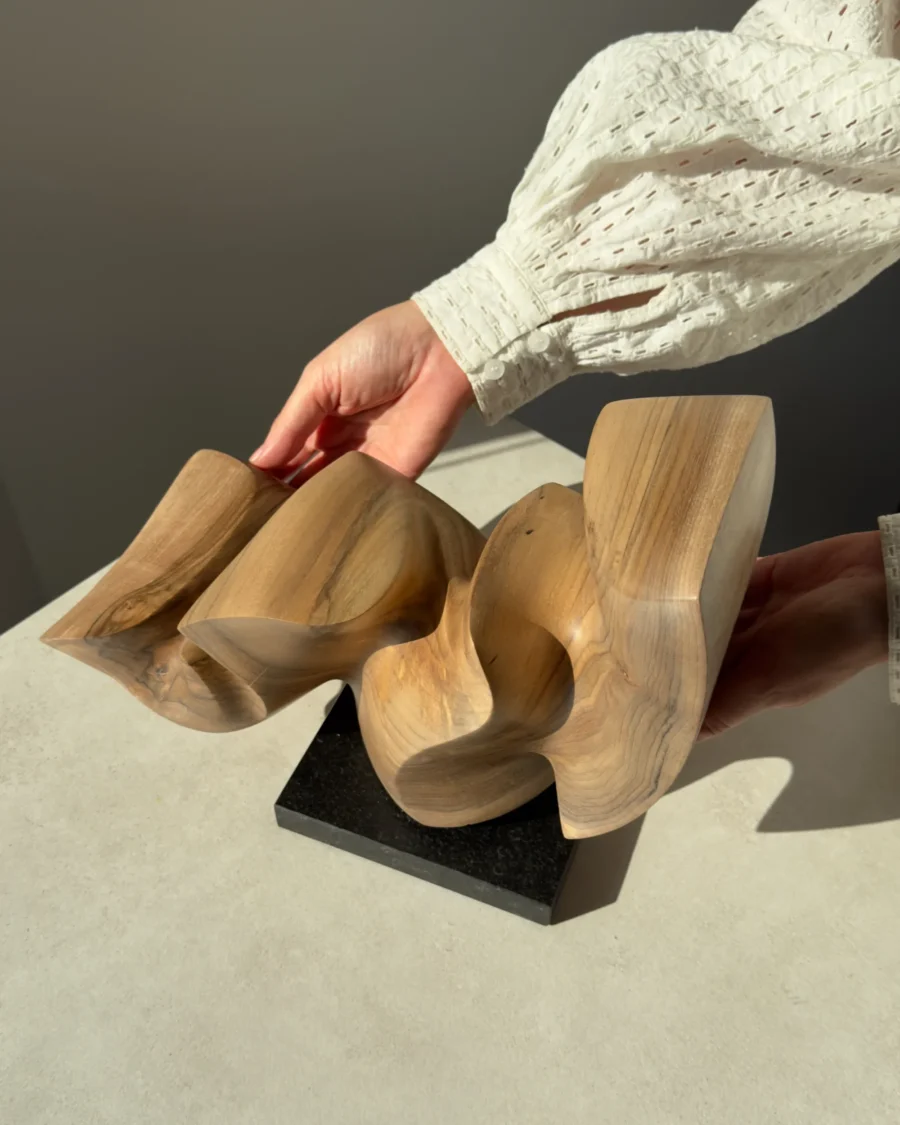 confluence-abstract-walnut-sculpture-top-view-in-hands-3 Top view of Confluence hand-carved walnut wood sculpture revealing flowing organic forms and continuous movement.