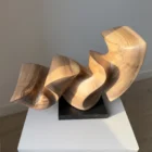 confluence-handmade-walnut-sculpture-detail-grain Three-quarter view of Confluence hand-carved walnut sculpture revealing smooth flowing surfaces.