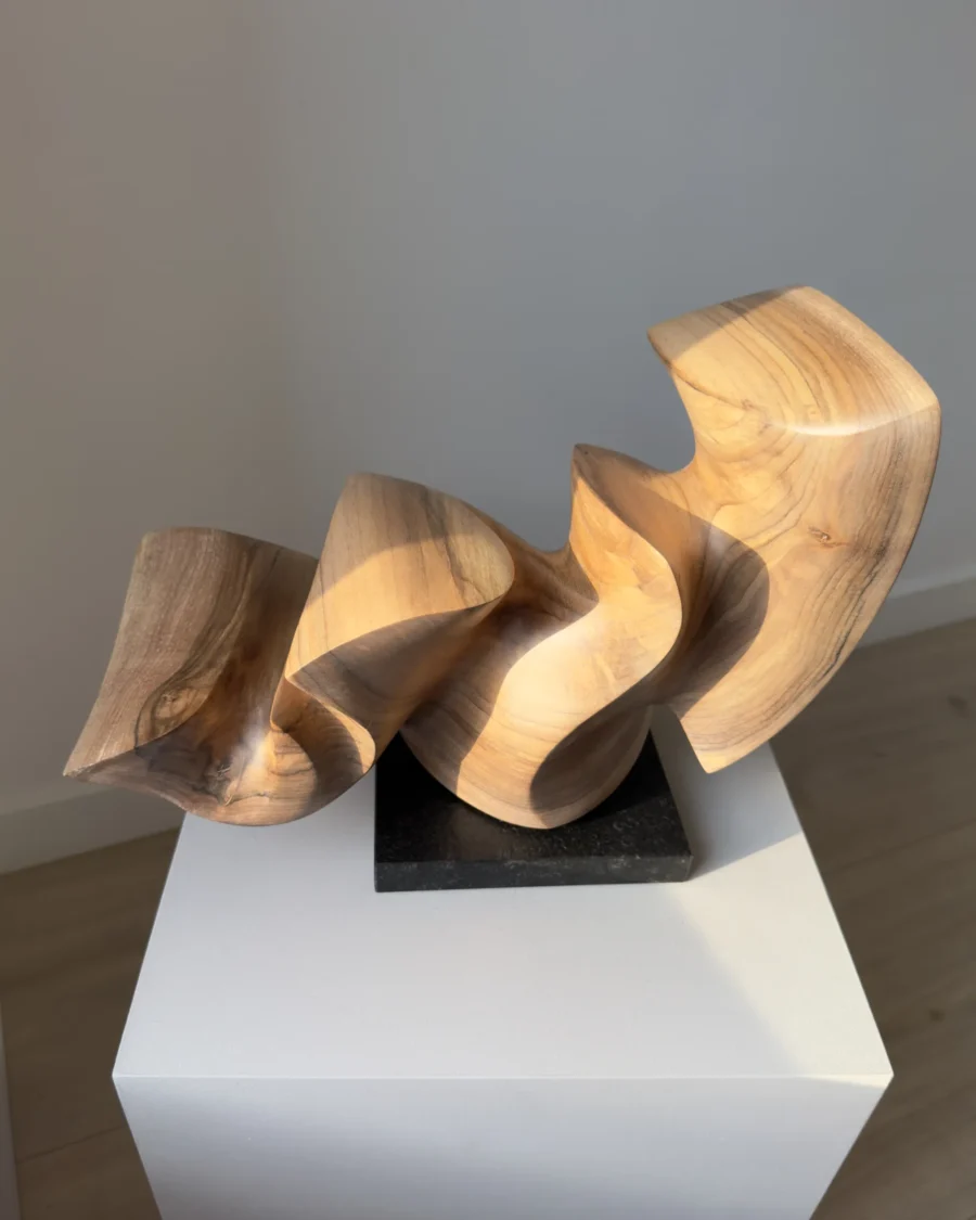 confluence-handmade-walnut-sculpture-detail-grain Three-quarter view of Confluence hand-carved walnut sculpture revealing smooth flowing surfaces.