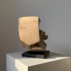 confluence-walnut-sculpture-side-profile-view-black-granite-base End view of Confluence abstract walnut wood sculpture showing layered curves and natural grain.