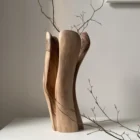 dualis-hand-carved-walnut-vase-gallery-view Dualis hand-carved walnut wood vase displayed with natural branches in a modern gallery-style interior.