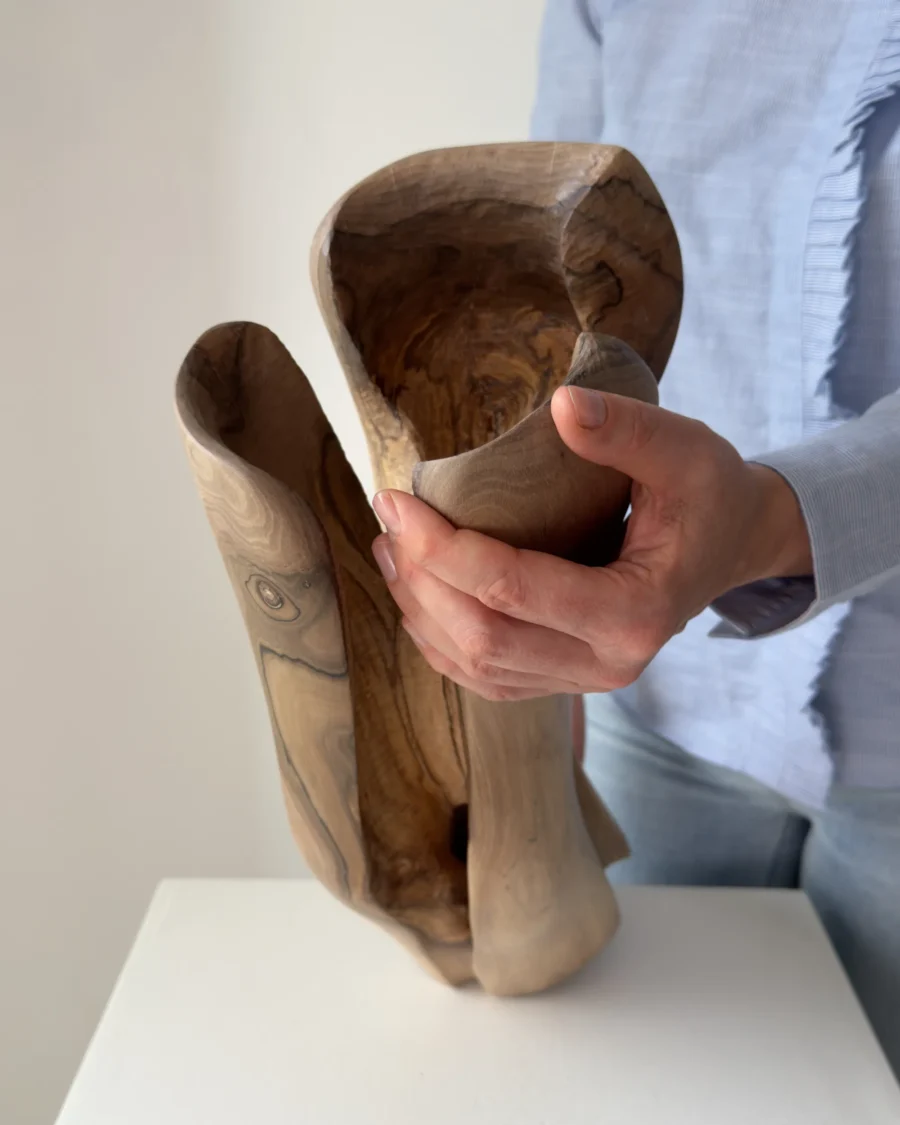 dualis-walnut-vase-held-in-hands Top view of the Dualis walnut vase revealing its sculpted interior and contrasting grain.